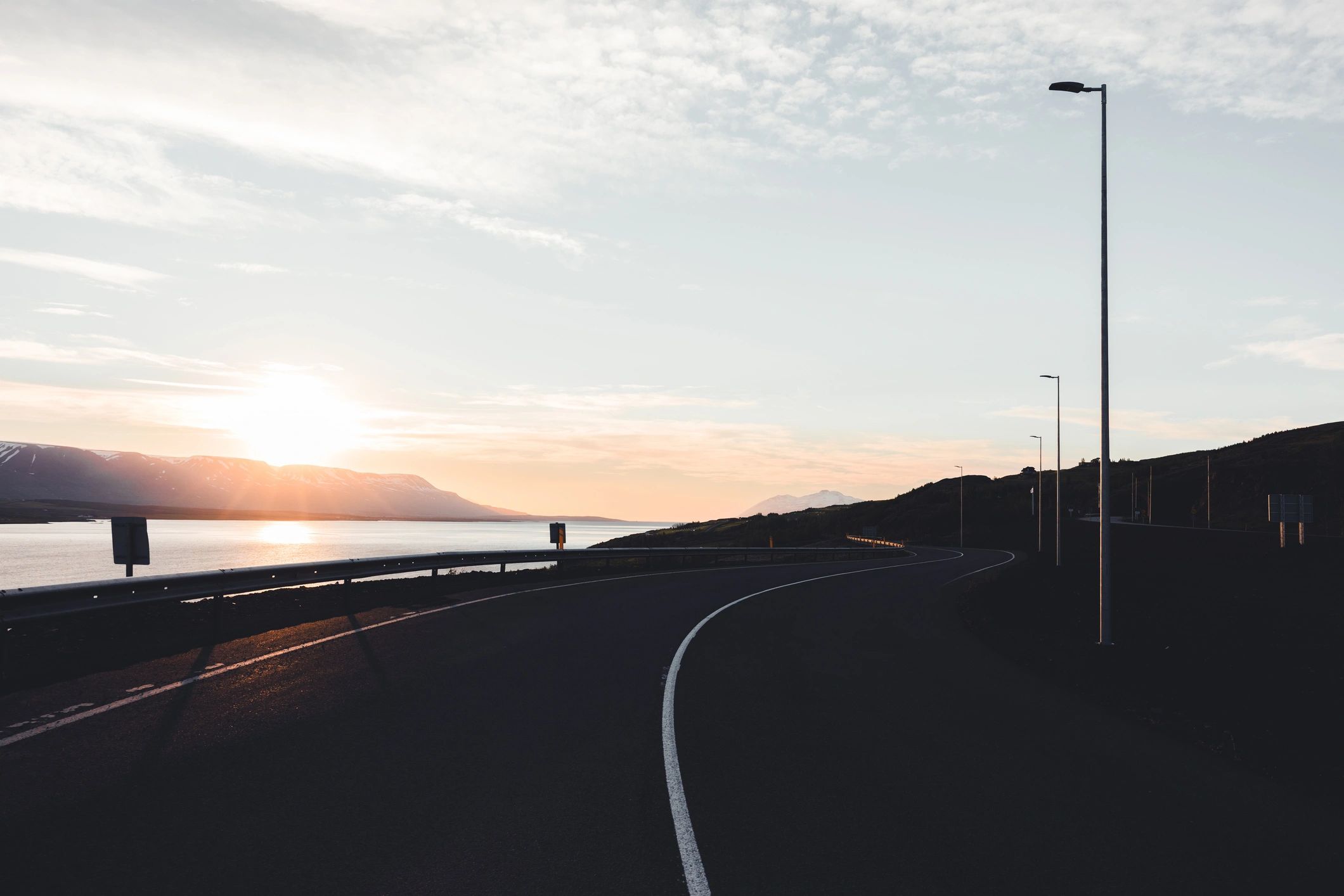 Coastal road curving along the sea at sunset